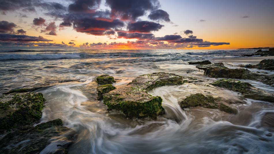 Aperture f/16 so the detail in the foreground rocks and clouds in the background are sharp