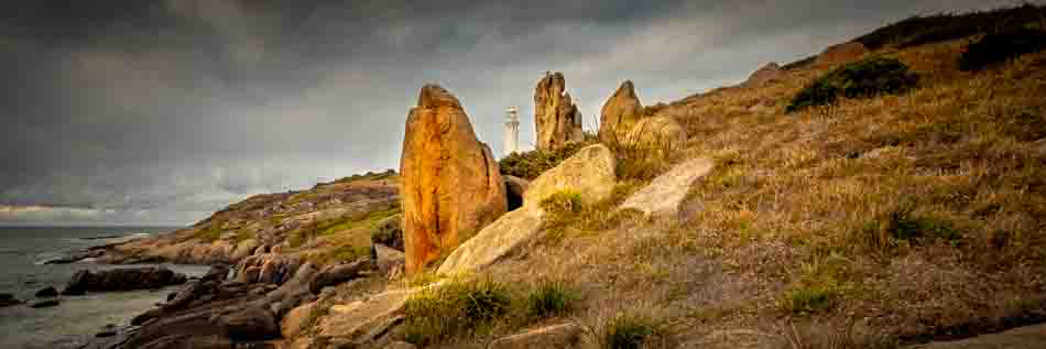 The rocks provide interesting framing for the lighthouse, drawing the viewer's attention.